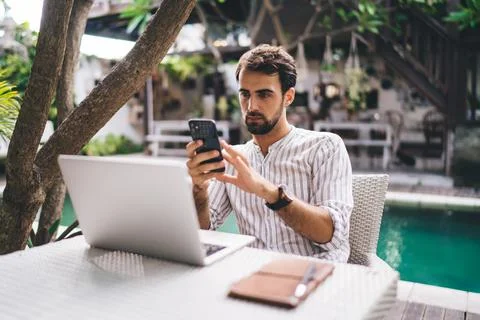 Thoughtful young man using smartphone for work Stock Photos