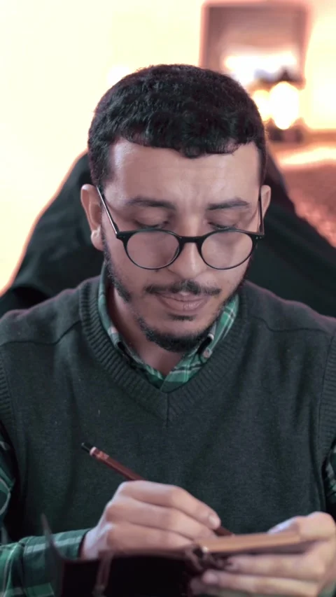 Thoughtful Young Middle Eastern Man Writing in Notebook Indoors Video stock 309770484