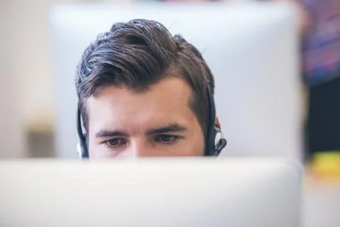 Thoughtful young programmer coding on computer 写真素材