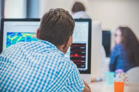 Thoughtful young programmer coding on computer Stock Photos