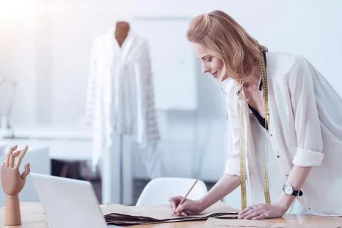 Thoughtful young tailor making notes on a pattern Stock Photos