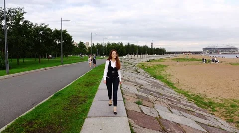 Thoughtful young woman go on shore front promenade, slow motion Stock Footage