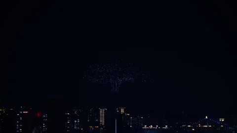 A thousand drones perform a technology tree-themed show in the city at night. Stock Footage 334299653