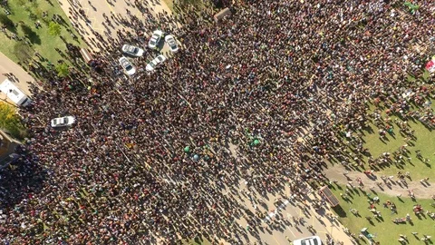 Thousands of people slowly marching in protest filmed by drone overhead Stock Footage 116794024