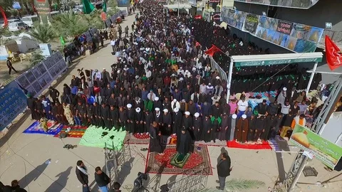 Thousands of pilgrims pray during Arbaeen pilgrimage at Najaf-Karbala Highway Stock Footage