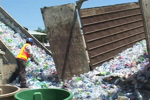 Thousands of plastic bottles are unloaded at a recycling center. Видео 341060