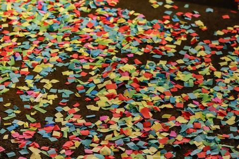Thousands of shredded papers, in square format, in various colors, on a dark Foto stock