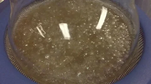 Thousands of small sodium balls stirring boiling in dioxane Stock Footage 228441784