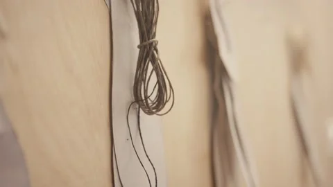Thread and patterns hanging on wooden wall in shoemaker's workshop Stock Footage 132724940