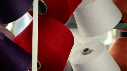 Thread bobbins rack textile factory. Close up red white yarn cones production. 動画素材 345889441
