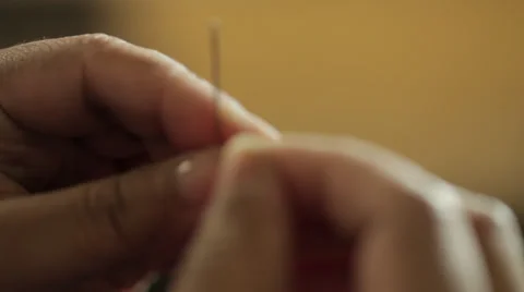 Thread cotton into a needle's hole Stock Footage 31450286