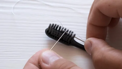 The thread enters the needle. A way to thread a needle for the elderly Stock Footage 128629677