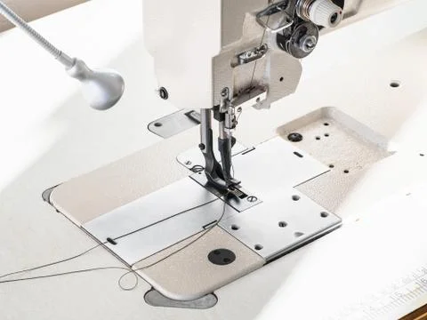 Thread in the needle of industrial sewing machine Stock Photos