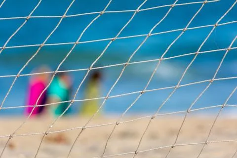 Thread net with pattern with blur people sitting on sandy beach Stock Photos