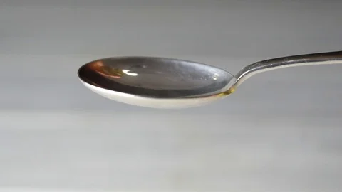 Thread olive oil dripping on spoon Stock-Footage 85299695