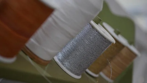 Thread roll bobbin hanging on storage Stock Footage 89775507