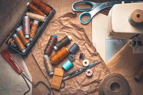 Thread, scissors and sewing accessories on a vintage background. Stock Photos