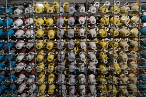 Thread spools of an industrial weaving loom for fabrication of f Stock Photos