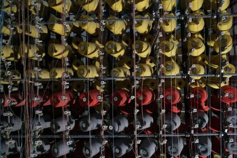 Thread spools of an industrial weaving loom for fabrication of f Stock Photos