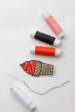 Thread spools, patch and needle on white background Stock Photos