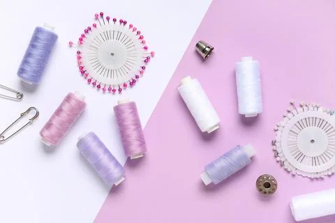 Thread spools with sewing pins on color background Stock Photos