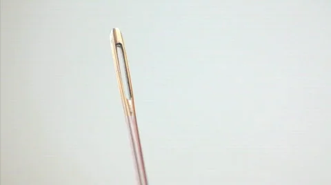 Thread Through the eye of a needle - Threading a needle, closeup Видео 325543