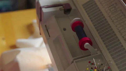 Thread Unwinds from Spool on Sewing Machine Stock Footage 336718261