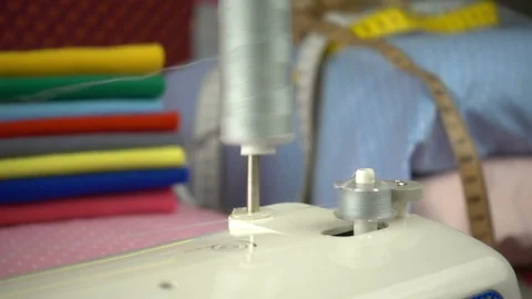 Thread is unwound from the reel during sewing to other coil in slow motion. Sewi Stock Footage 100200075
