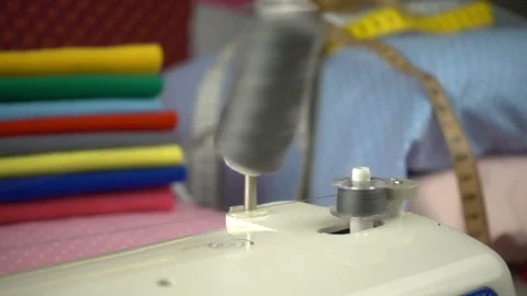 Thread is unwound from the reel during sewing to other coil in slow motion. Sewi Stock Footage 100200187