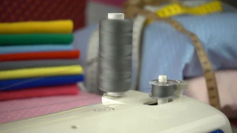 Thread is unwound from the reel during sewing to other coil in slow motion. Sewi Stock Footage 100200292