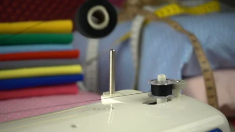 Thread is unwound from the reel during sewing to other coil in slow motion. Sewi Video stock 100200305