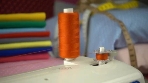 Thread is unwound from the reel during sewing to other coil in slow motion. Sewi Stock Footage 100200327