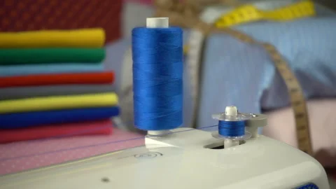 Thread is unwound from the reel during sewing to other coil in slow motion. Sewi Stock Footage 100200413
