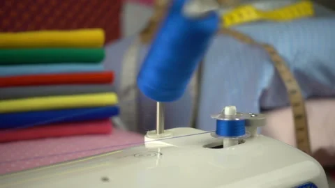 Thread is unwound from the reel during sewing to other coil in slow motion. Sewi Stock Footage 100200427