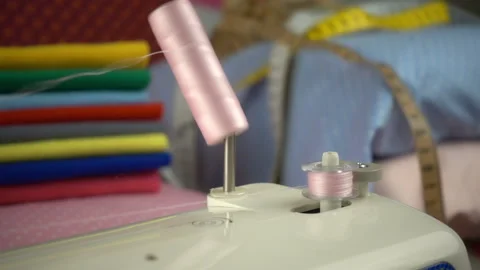 Thread is unwound from the reel during sewing to other coil in slow motion. Sewi Stock Footage 100200469