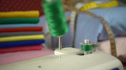 Thread is unwound from the reel during sewing to other coil in slow motion. Sewi Stock Footage 100200507