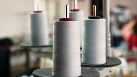 The thread is unwound from the spool while sewing by a seamstress on a sewing Stock Footage 199307298