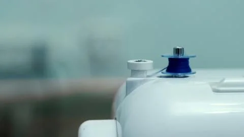 The thread is unwrapped from the coil of the sewing machine Stock Photos
