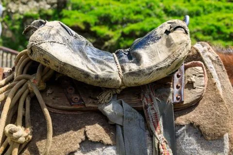 Threadbare old saddle on a shepherd's horse, handmade saddle of a peasant she Stock Photos