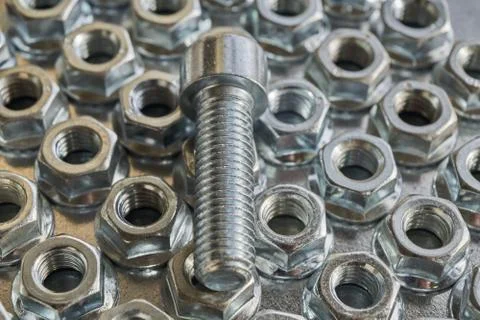 The threaded bolt lies on the shiny hex nuts. Foto stock