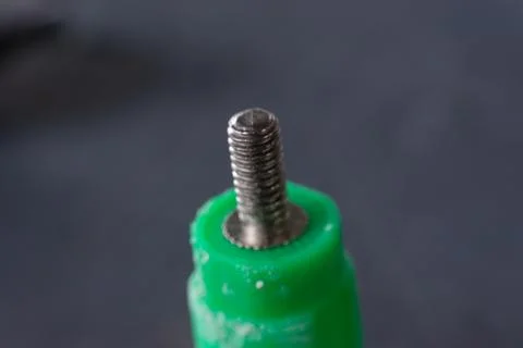 Threaded Metal Stud in Green Plastic Part Stock-Fotos