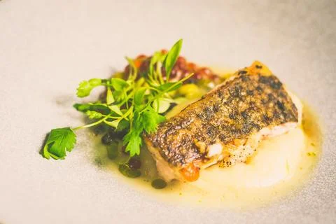 Threadfin with yucca mash, fermented tomato fish jus, laksa oil, pickled fa.. Stock Photos