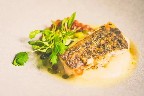 Threadfin with yucca mash, fermented tomato fish jus, laksa oil, pickled fa.. Stock Photos