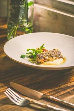 Threadfin with yucca mash, fermented tomato fish jus, laksa oil, pickled fa.. Stock Photos