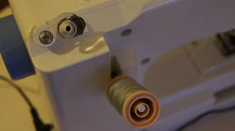 Threading a bobbin on a white sewing machine with grey thread. Stock Footage 52181232