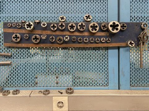 Threading dies of different sizes and metrics in the tool panel of a machine Stock Photos