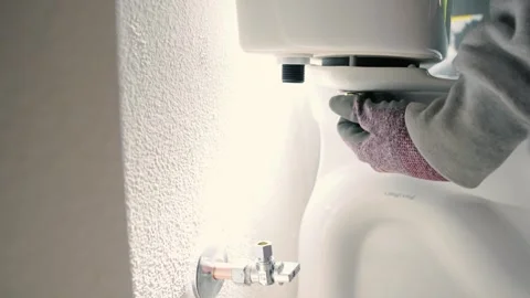 Threading a nut onto the underside of a toilet basin Stock Footage 281993183