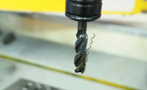 A threading tap tool mounted on a CNC machine spindle. Stock Photos