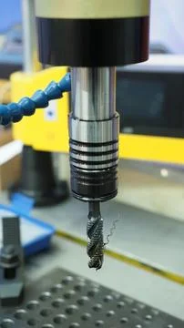 A threading tap tool mounted on a CNC machine spindle. Stock Photos