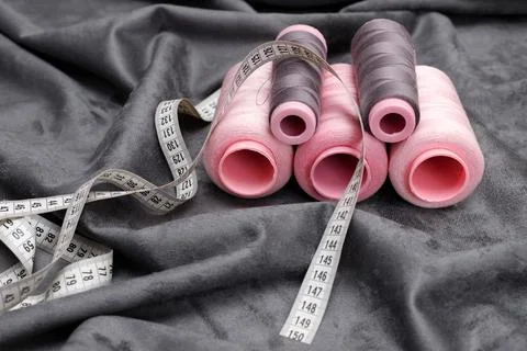 Threads and centimeters on the gray fabric. seamstress Stock-Fotos